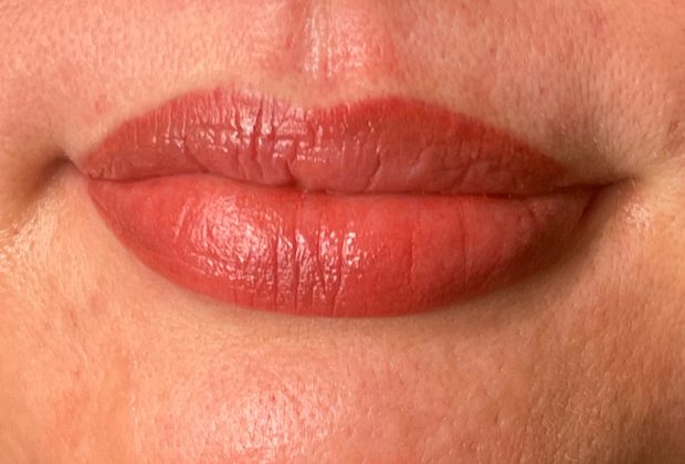 A close up of a woman 's lips with red lipstick.